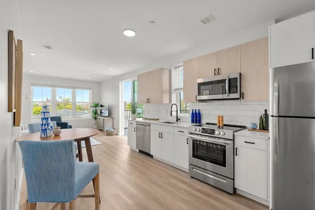 a kitchen with white cabinets and stainless steel appliances