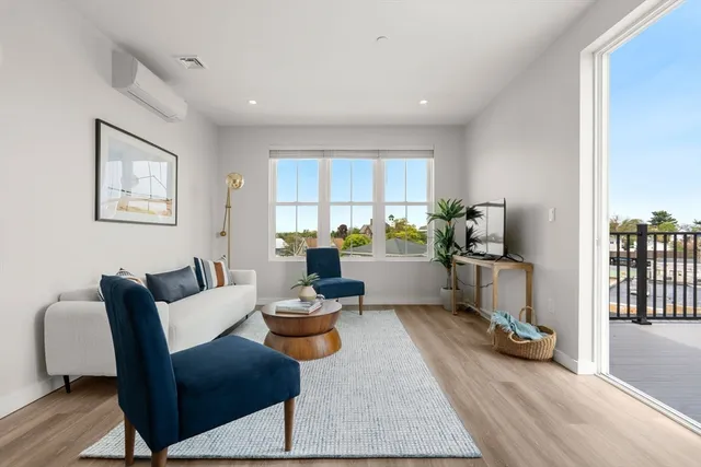 a living room with furniture and a wooden floor