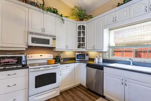 a kitchen with granite countertop a sink and cabinets