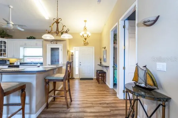 a view of a dining room and livingroom with furniture wooden floor a chandelier