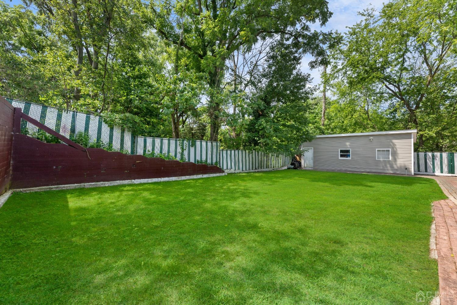 16 Parson Place Colonia, NJ 07067 - Photo 61 of 70 a view of a backyard with large trees and wooden fence