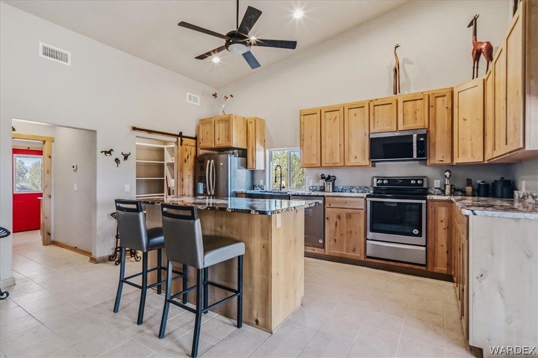 10374 East Happy Trails Road Kingman, AZ 86401 - Photo 16 of 68 a kitchen with stainless steel appliances a stove a sink island and a refrigerator