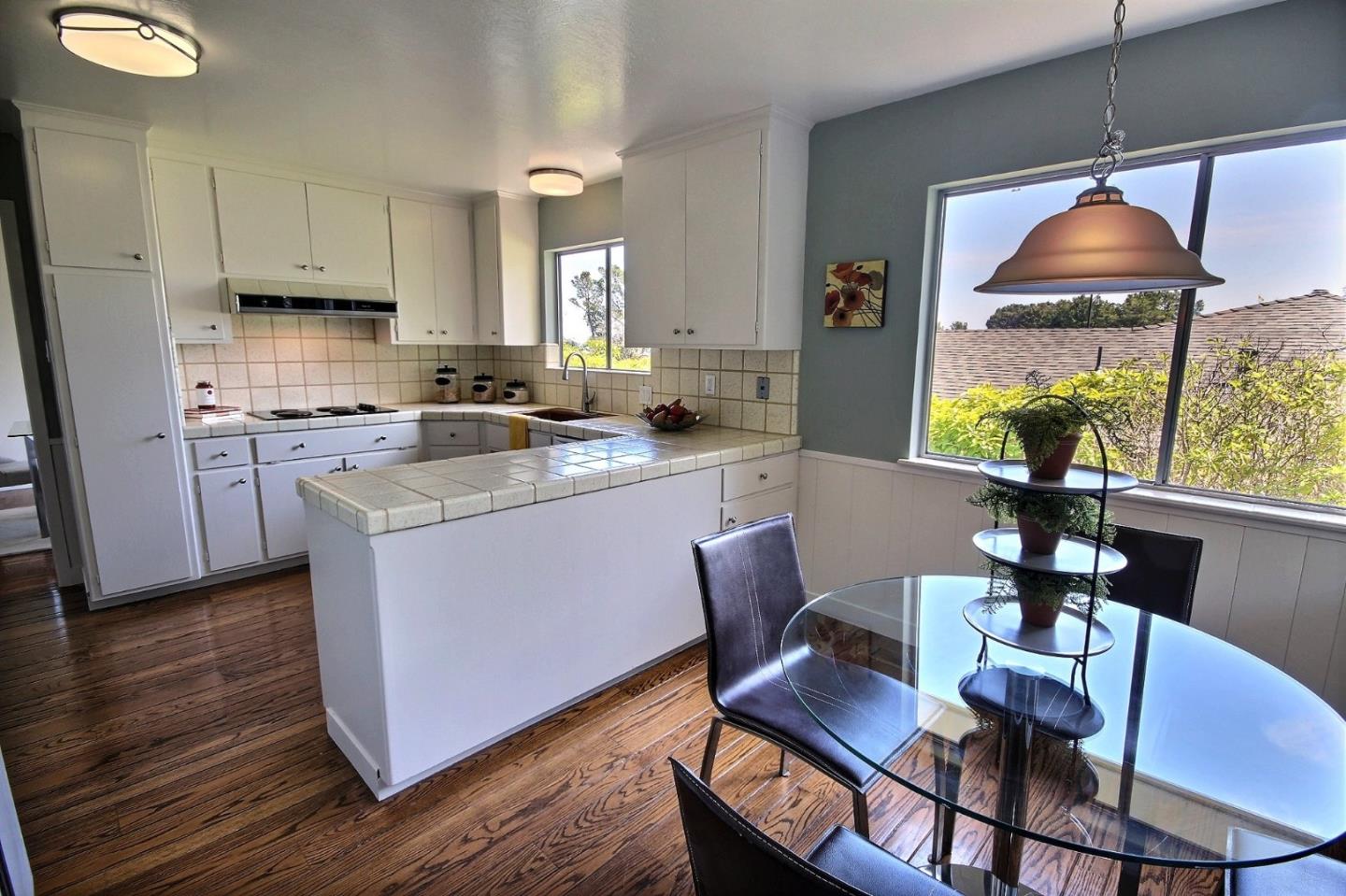 1817 Hunt Drive Burlingame, CA 94010 - Photo 9 of 20 a kitchen with stainless steel appliances granite countertop a stove a sink a microwave a dining table and chairs with wooden floor