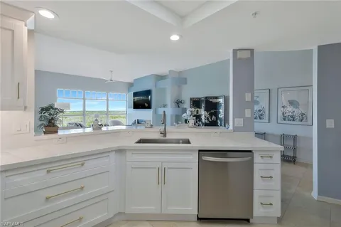 a kitchen with granite countertop white cabinets and white appliances
