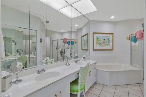 a bathroom with a double vanity sink mirror and bathtub