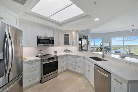 a kitchen with stainless steel appliances a stove sink microwave refrigerator and cabinets