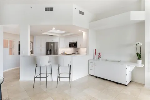 a kitchen with a sink and chairs
