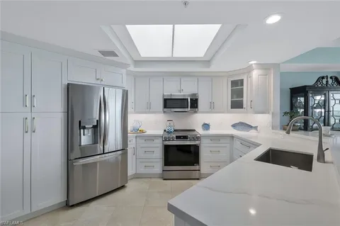 a kitchen with stainless steel appliances granite countertop a refrigerator stove microwave and sink