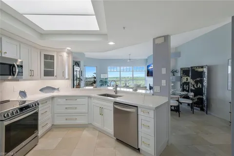 a kitchen with white cabinets and appliances