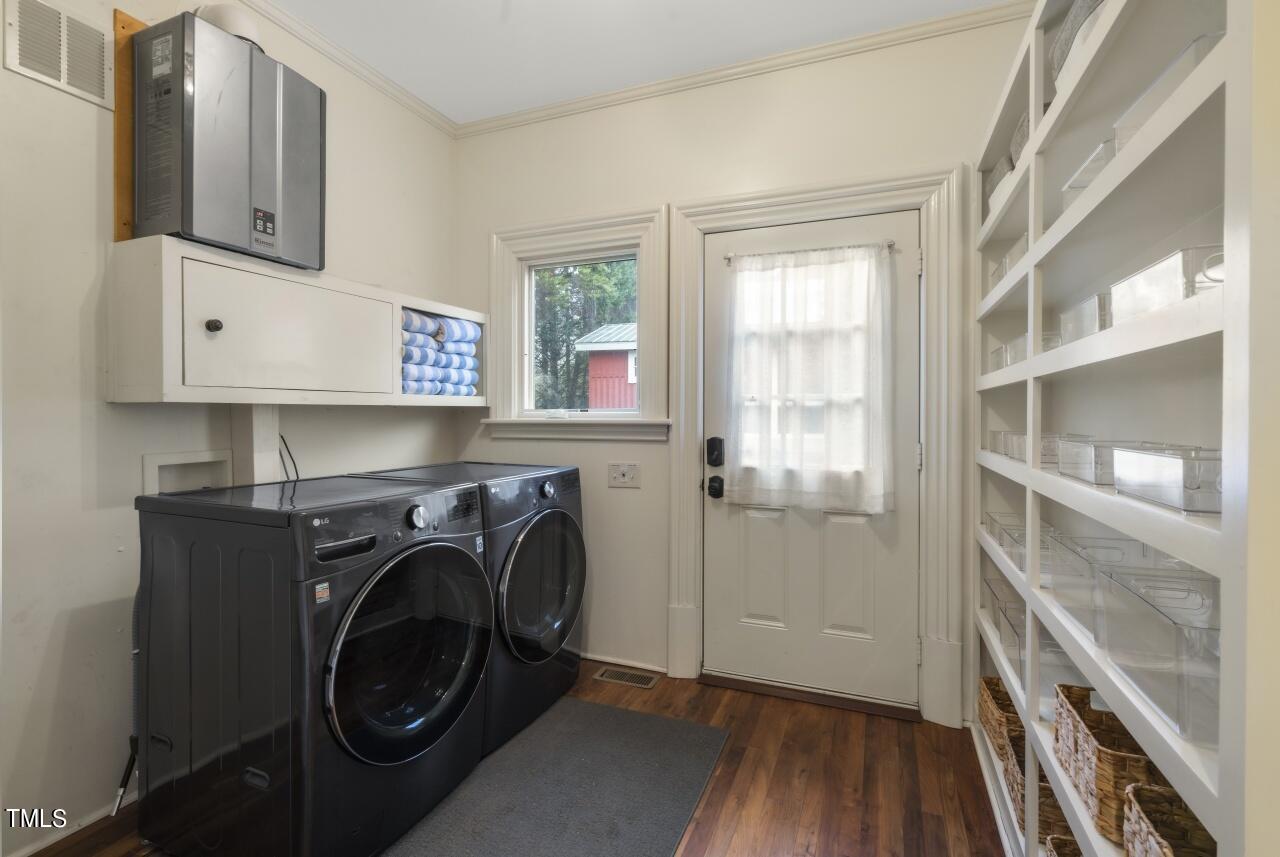 5612 Cabe Ford Road Durham, NC 27705 - Photo 32 of 42 a utility room with cabinets dryer and washer