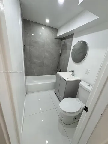 a white toilet sitting next to a bathroom sink and tub