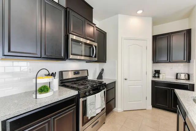a kitchen with stainless steel appliances granite countertop a stove microwave and sink