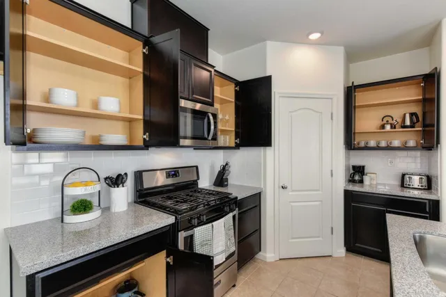 a kitchen with stainless steel appliances a sink a stove and a refrigerator