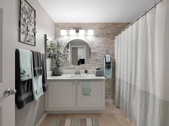 a bathroom with a sink and mirror with toilet