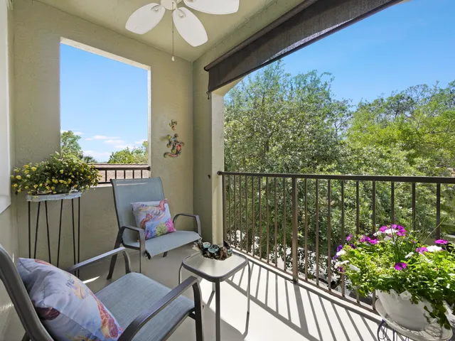 a balcony with wooden floor table and chairs