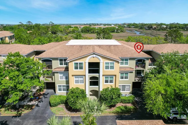 an aerial view of a houses with a yard and lake view