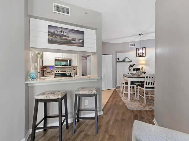 a kitchen with stainless steel appliances granite countertop a table chairs and a refrigerator
