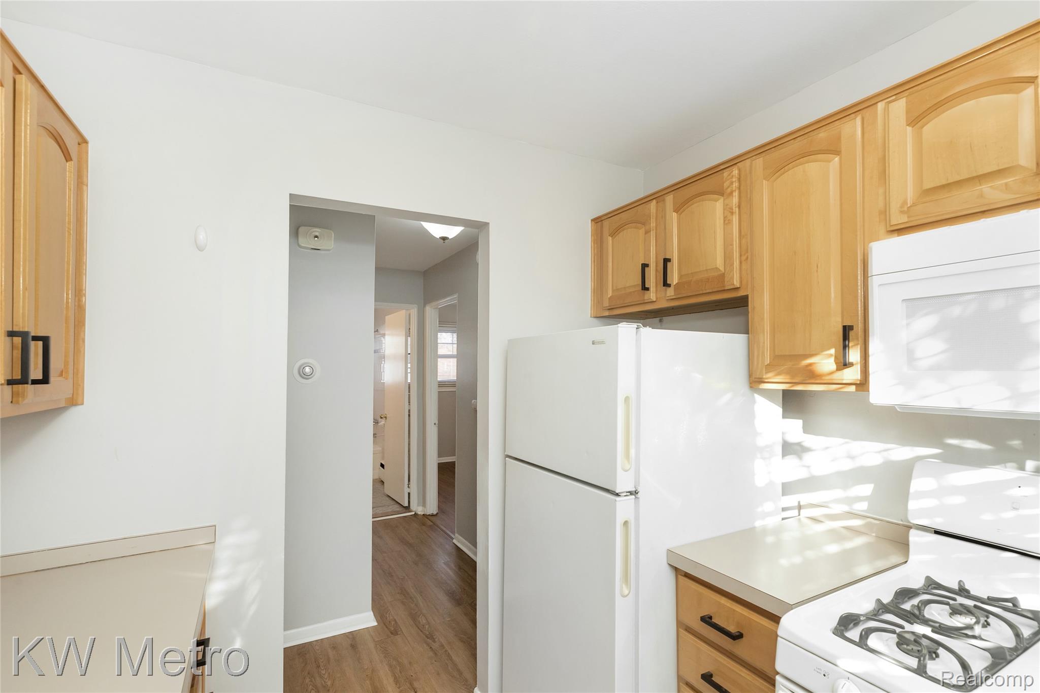 2817 West 13 Mile Road Royal Oak, MI 48073 - Photo 11 of 21 Kitchen with white appliances, light countertops, light wood-type flooring, and light brown cabinetry
