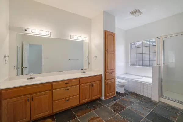 a bathroom with a granite countertop sink a toilet and bathtub