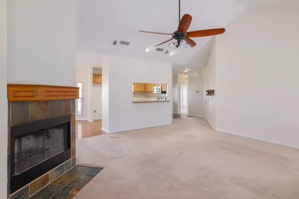 an empty room with windows and fireplace