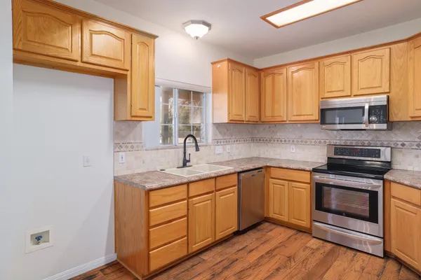 a kitchen with stainless steel appliances granite countertop a sink stove and cabinets