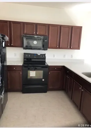 a kitchen with granite countertop a stove top oven and cabinets