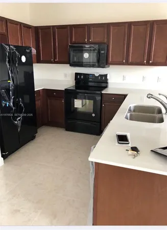 a kitchen with a sink a stove and cabinets