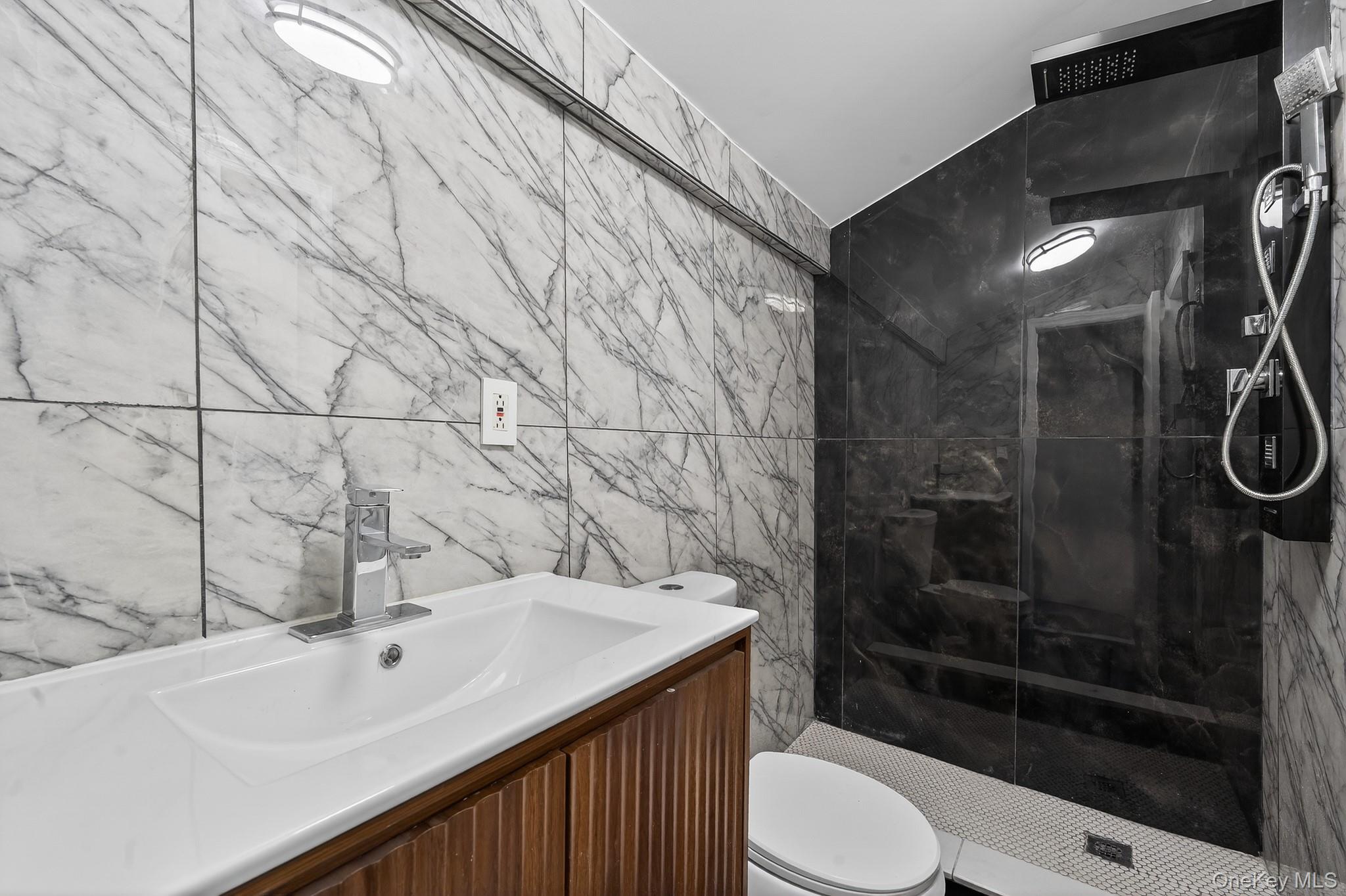 136-03 220th Street Queens, NY 11413 - Photo 18 of 27 a bathroom with a sink a toilet and shower