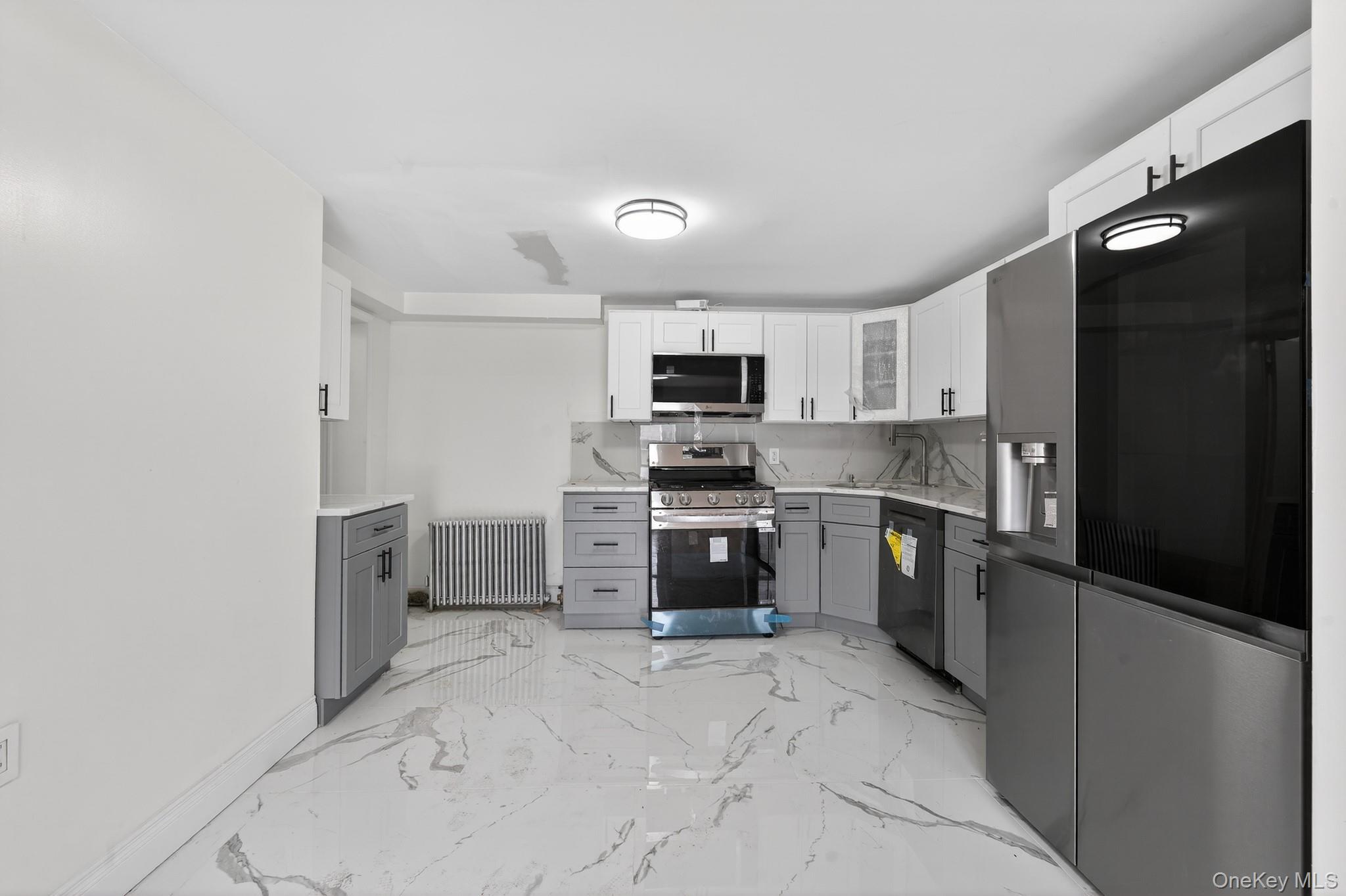 136-03 220th Street Queens, NY 11413 - Photo 27 of 27 a kitchen with granite countertop a refrigerator and a stove top oven