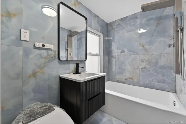 a bathroom with a sink a mirror and a bathtub