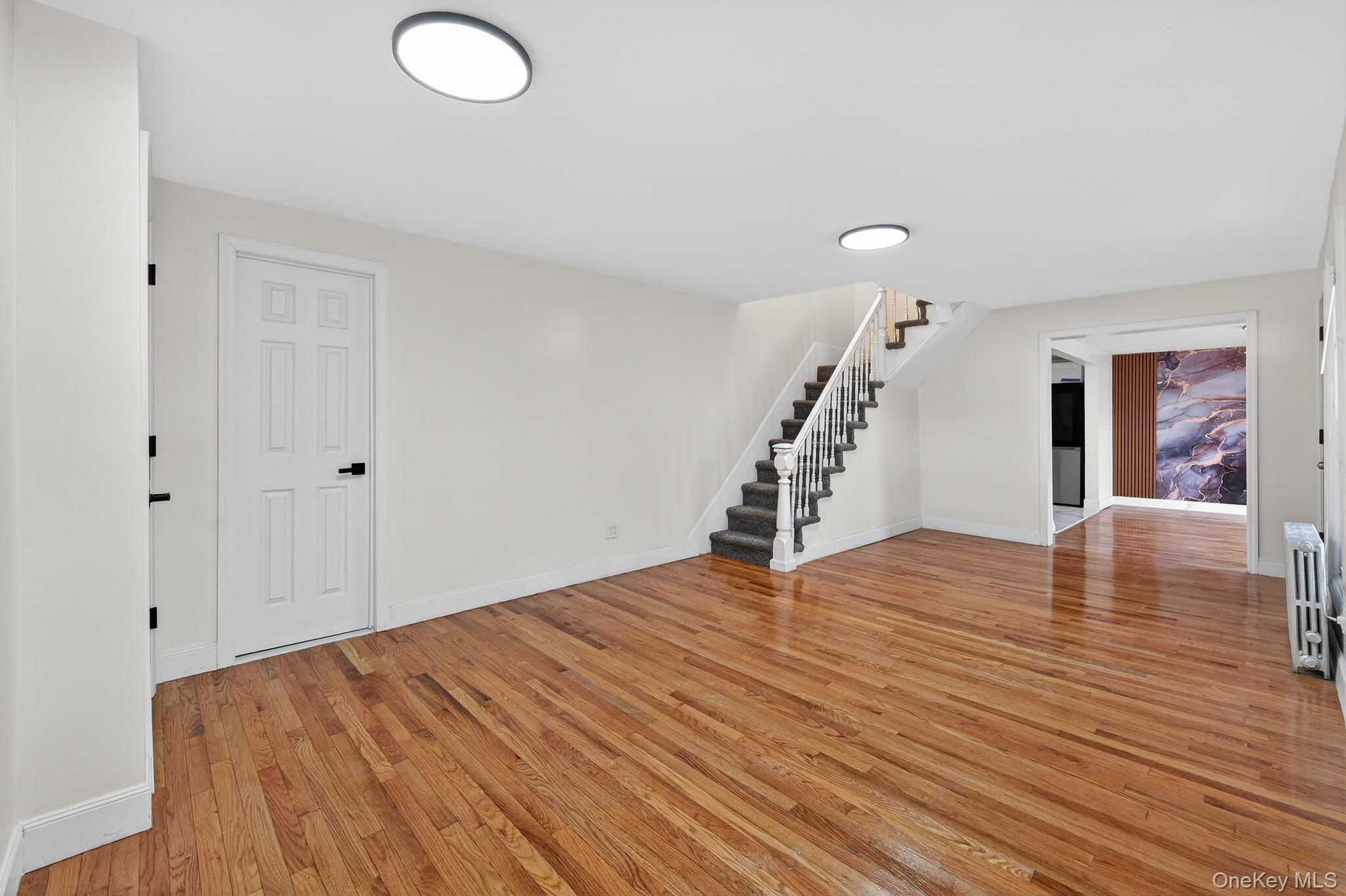 136-03 220th Street Queens, NY 11413 - Photo 10 of 27 a view of empty room with wooden floor