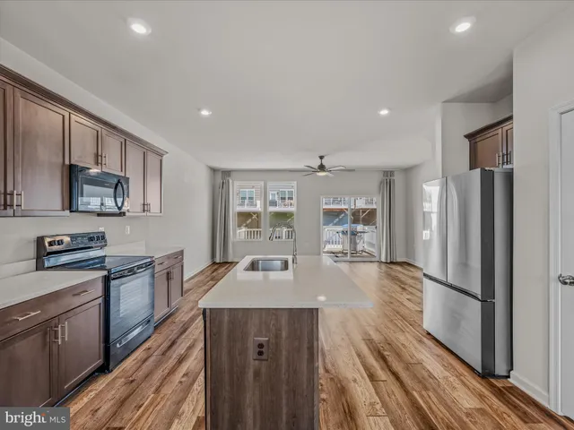 a kitchen with stainless steel appliances granite countertop lots of counter top space and wooden floor