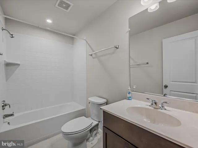 a bathroom with a granite countertop sink a toilet and shower