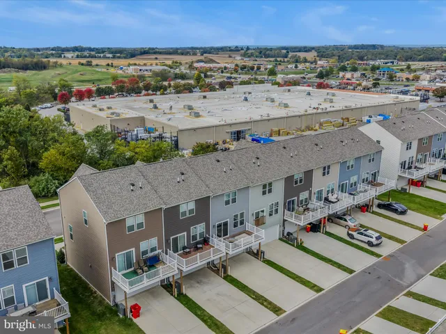 an aerial view of a city with lots of residential buildings and mountain view in back
