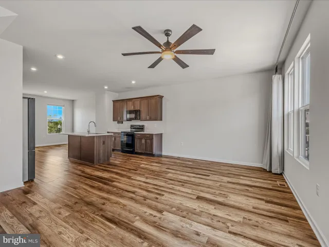 a view of a livingroom with a ceiling fan and wooden floor