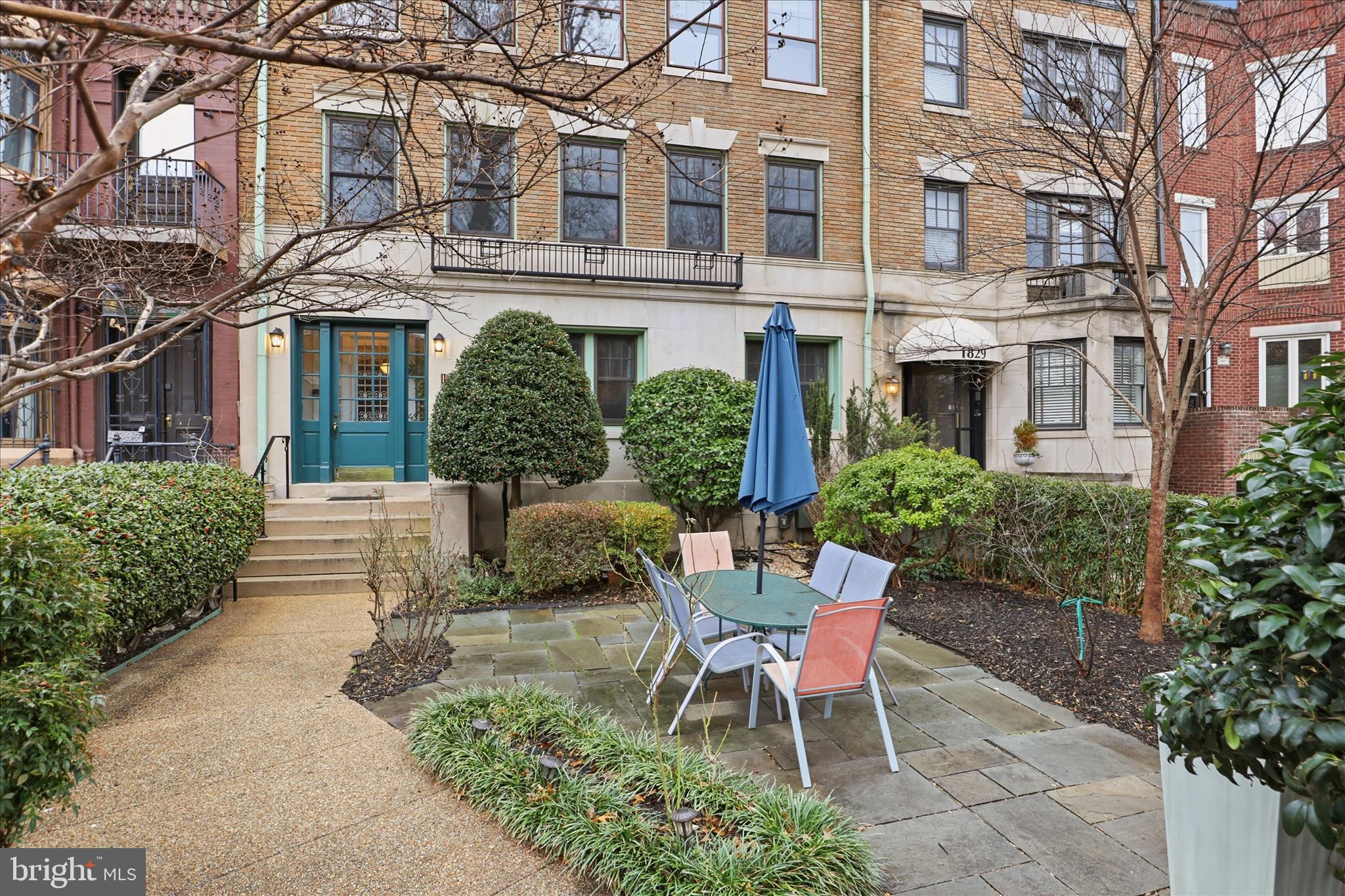 a view of a building with a chairs and table in a patio