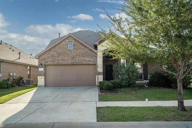 a front view of a house with a yard and a garden