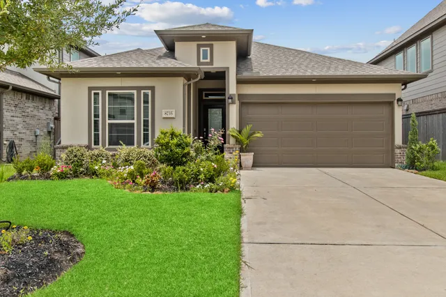 a front view of a house with a yard and garage