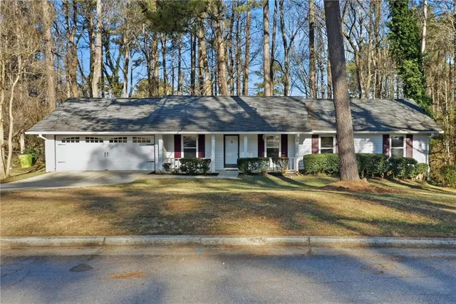 a view of a house with a large tree next to a road
