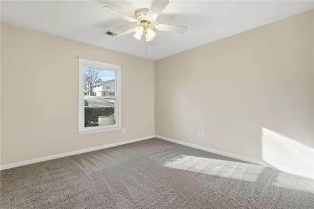 an empty room with a window and a fan