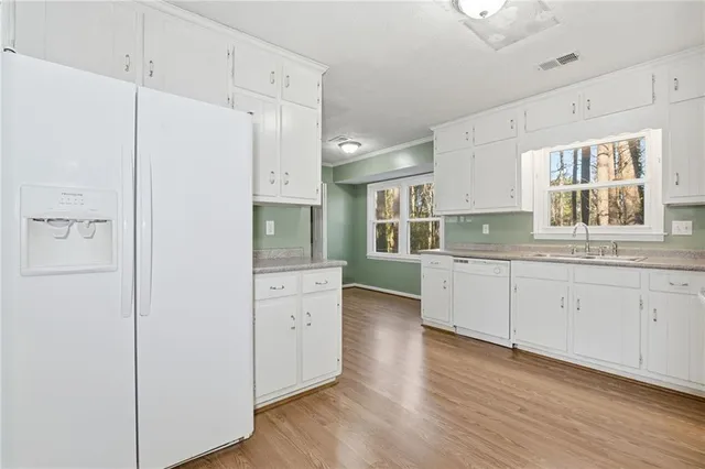 a kitchen with granite countertop white cabinets and white appliances