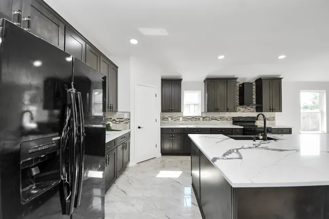 a kitchen with a sink refrigerator and cabinets