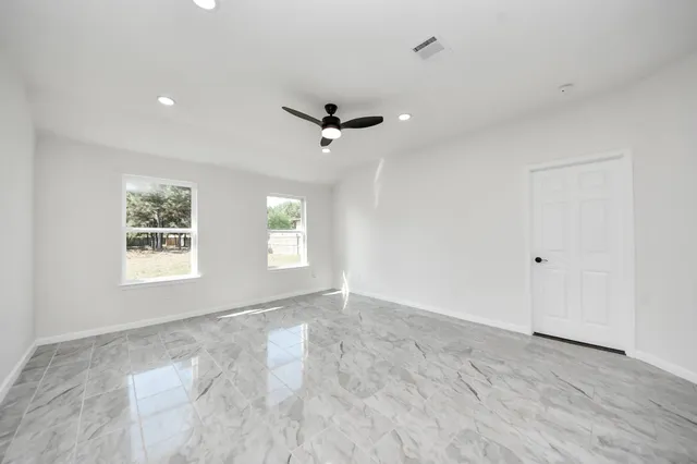 a view of a livingroom with a ceiling fan and window