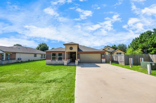 a view of a house with a yard and sitting area