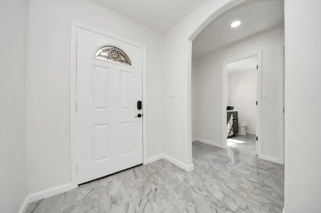 a view of a big room with windows and chandelier fan