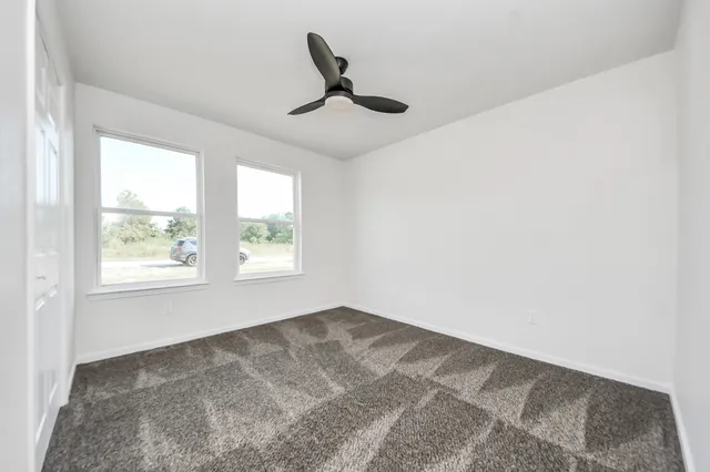 a view of a livingroom with a ceiling fan and window