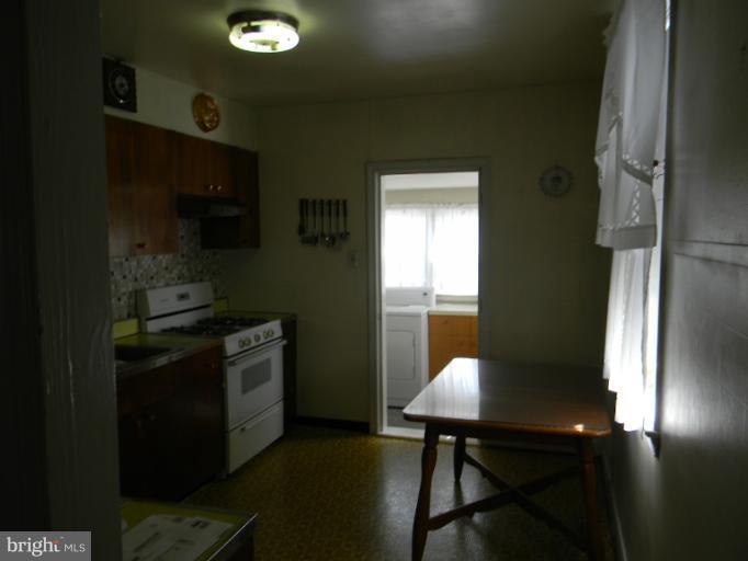 226 Pinewood Road Dundalk, MD 21222 - Photo 6 of 12 a kitchen with a table chairs and a refrigerator