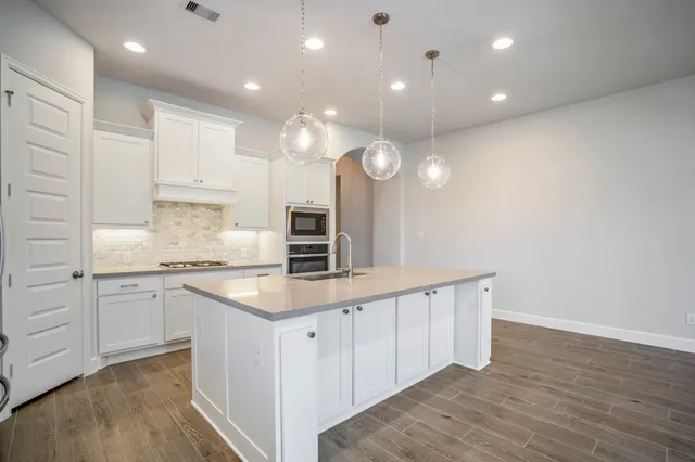 a kitchen with cabinets and wooden floor