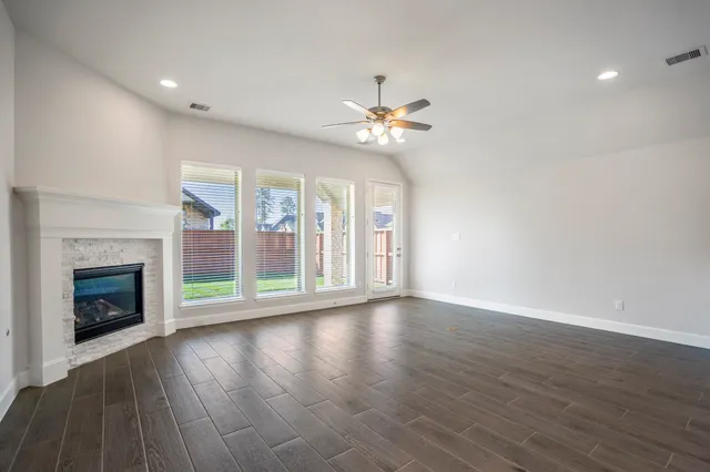 a view of an empty room with a fireplace and a window