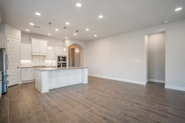 a large kitchen with stainless steel appliances granite countertop a large counter top a sink and a stove